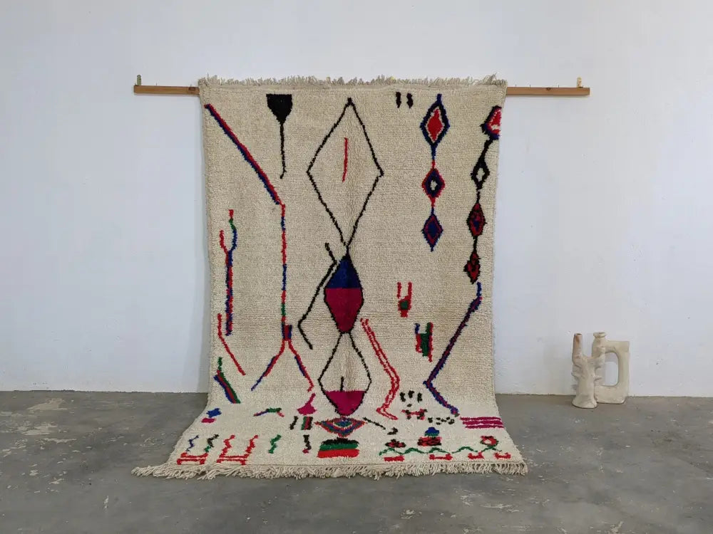 Beige moroccan handmade azilal rug with bold red blue and purple geometric patterns in pure natural wool 265x161 cm