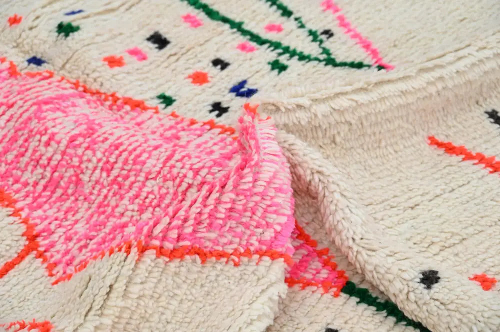 A vibrant moroccan handmade traditional azilal rug with a cream base and bold geometric patterns in multiple colors