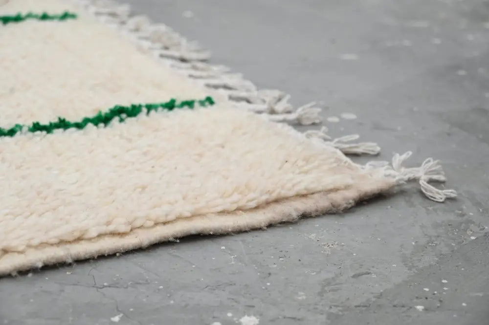Cream-colored wool moroccan handmade traditional azilal rug with green horizontal stripes and fringed edges 268 x 157 cm
