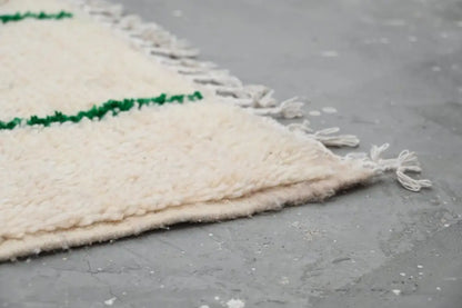 Cream-colored wool moroccan handmade traditional azilal rug with green horizontal stripes and fringed edges 268 x 157 cm