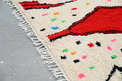 Cream-colored moroccan handmade traditional azilal rug with bold red black geometric patterns and colorful polka dots