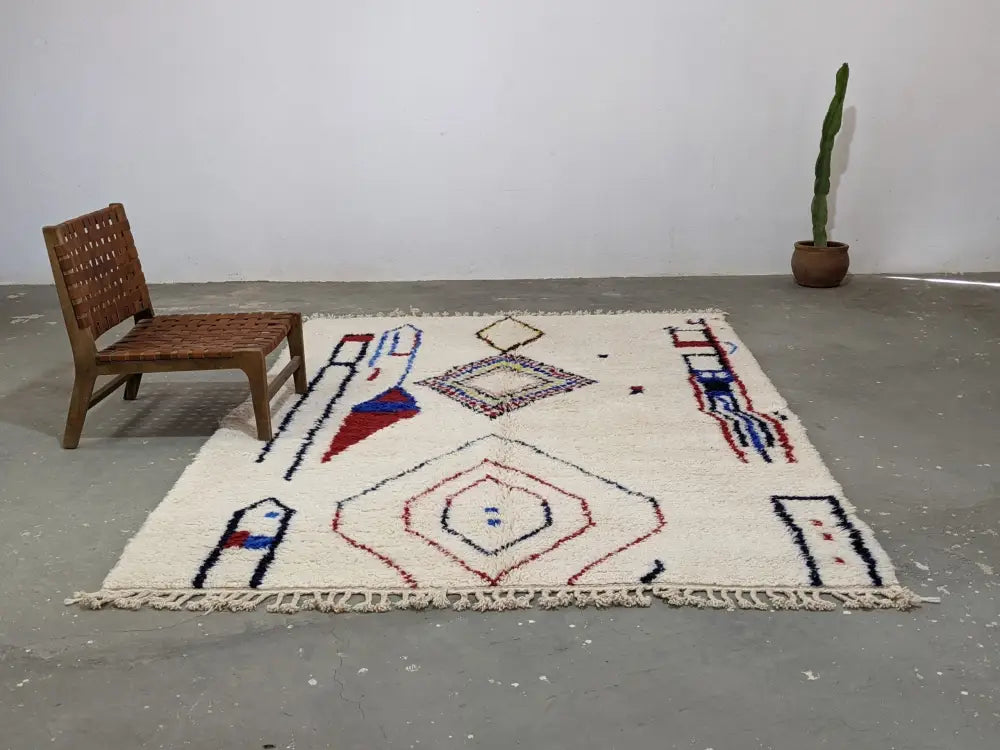 Cream-colored DecorBites™ moroccan handmade traditional azilal rug with red blue black geometric patterns and fringed edges