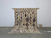 Beige moroccan handmade traditional azilal rug with intricate purple blue and brown geometric patterns and fringed edges