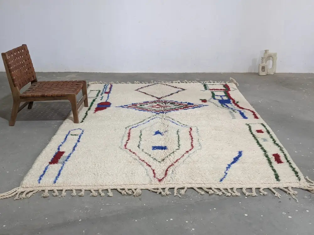 Cream-colored moroccan handmade traditional azilal rug with geometric blue red and green patterns by decorbites 300 x 210 cm