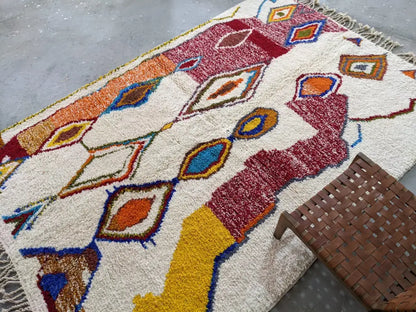 Decorbites™ moroccan handmade traditional azilal rug with plush cream base and bold red, orange, blue, and yellow patterns