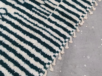 A plush moroccan handmade traditional azilal rug in deep teal and off-white with soft tassels by decorbites