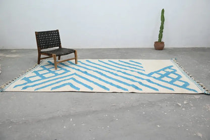 Cream-colored moroccan handmade traditional azilal rug with bold blue geometric stripes and fringed edges 320 x 200 cm
