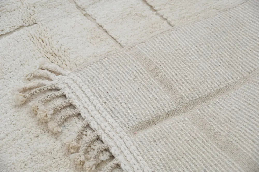 Off-white moroccan handmade beni ouarain carpet with textured surface and fringed edges by DecorBites™ 305 x 202 cm