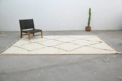 Cream-colored moroccan handmade beni ouarain carpet with black geometric diamond patterns and fringed edges 310 x 215 cm
