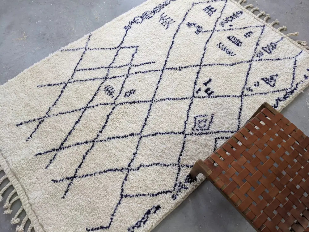 Cream-colored beni ouarain rug with black geometric patterns and fringed edges moroccan handmade 244 x 157 cm