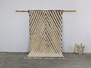 Cream-colored textured wool beni ouarain rug with bold black zigzag stripes and fringed edges moroccan handmade