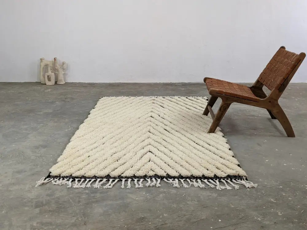 Cream-colored chunky knitted beni ouarain rug with bold chevron pattern and black border trim moroccan handmade