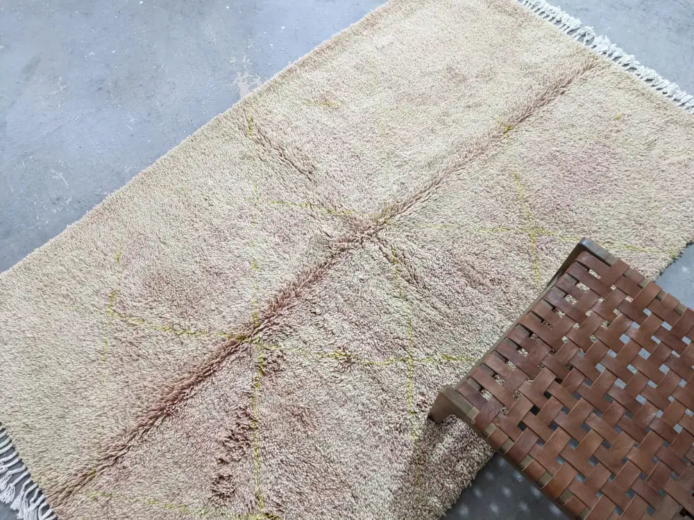 Beige shaggy wool beni ouarain rug with fringed edges and faded pinkish brown patches by decorbites 250 x 154 cm