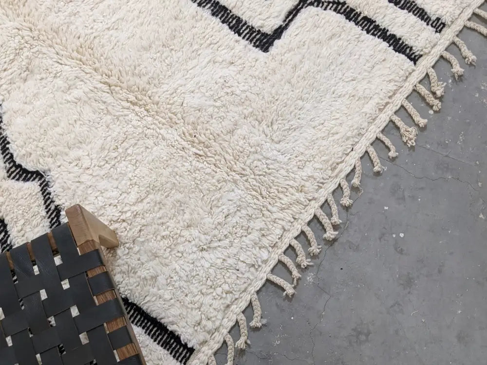 Cream-colored plush wool beni ouarain rug with bold black geometric patterns and fringed edges moroccan handmade