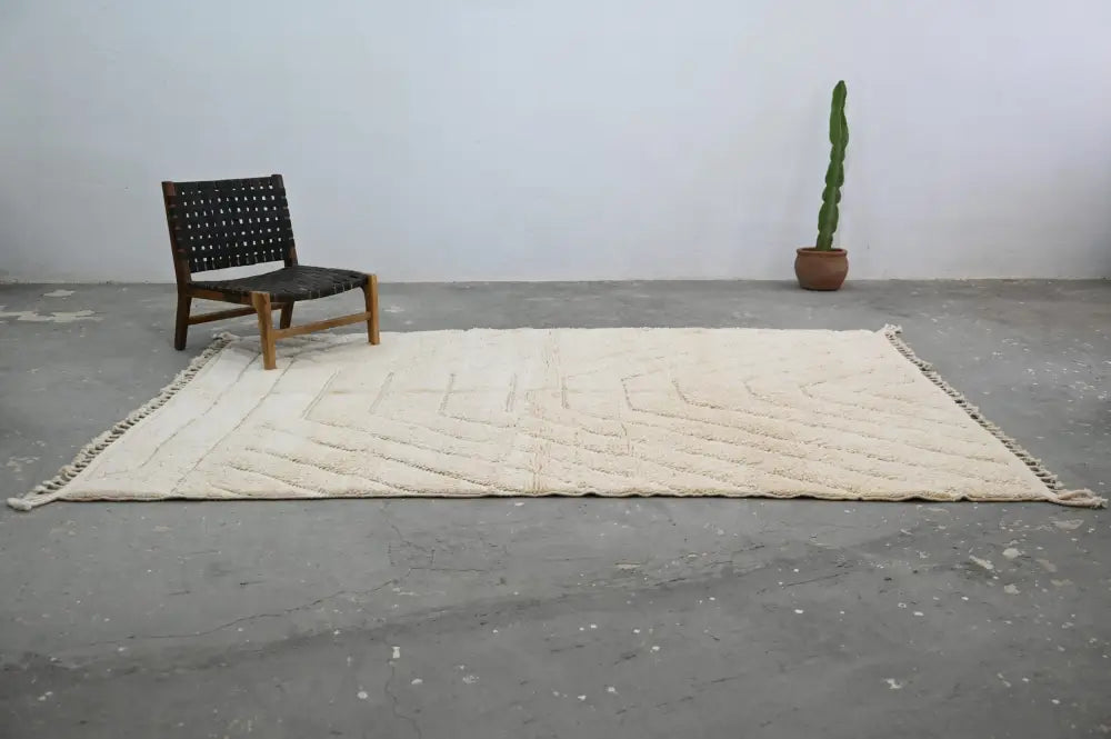 Cream-colored textured wool beni ouarain rug with geometric pattern and fringed edges by decorbites 285 x 205 cm