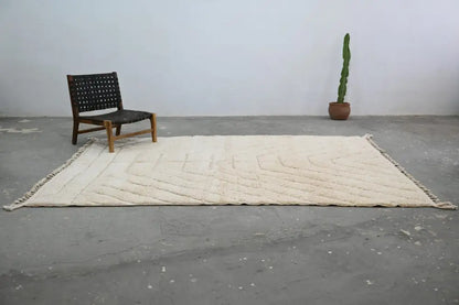 Cream-colored textured wool beni ouarain rug with geometric pattern and fringed edges by decorbites 285 x 205 cm