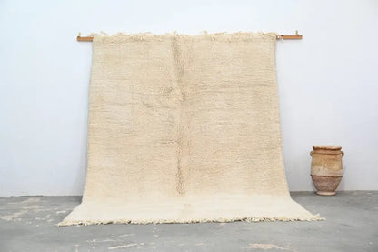 Cream-colored beni ouarain rug with textured fringed edges moroccan handmade natural fiber traditional design