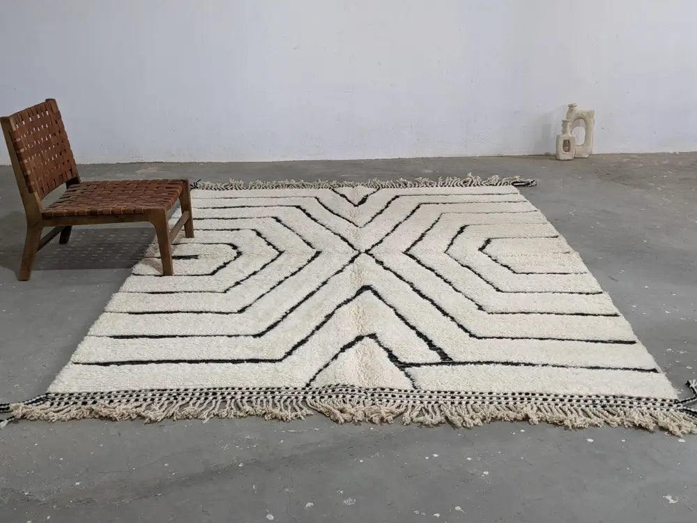 Cream-colored beni ouarain rug with bold black geometric patterns and fringed edges moroccan handmade wool rug