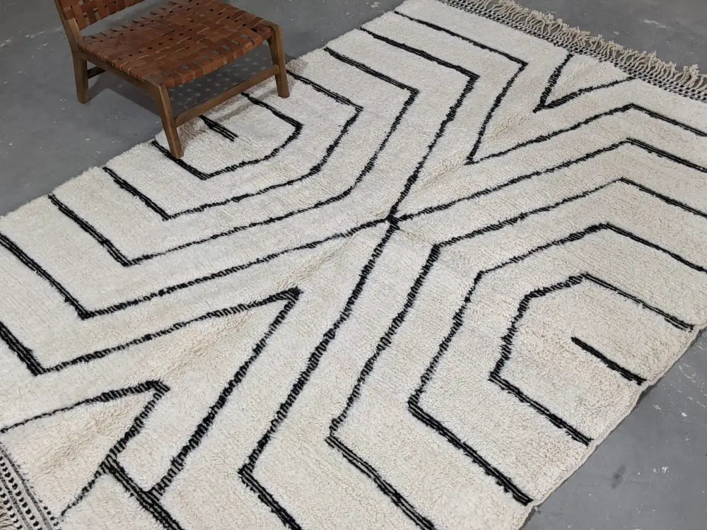 Cream-colored beni ouarain rug with bold black geometric patterns and fringed edges moroccan handmade wool rug