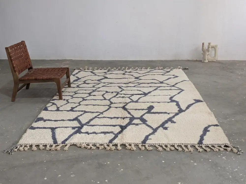 Cream-colored beni ouarain rug with dark blue geometric pattern and fringed edges moroccan handmade traditional design