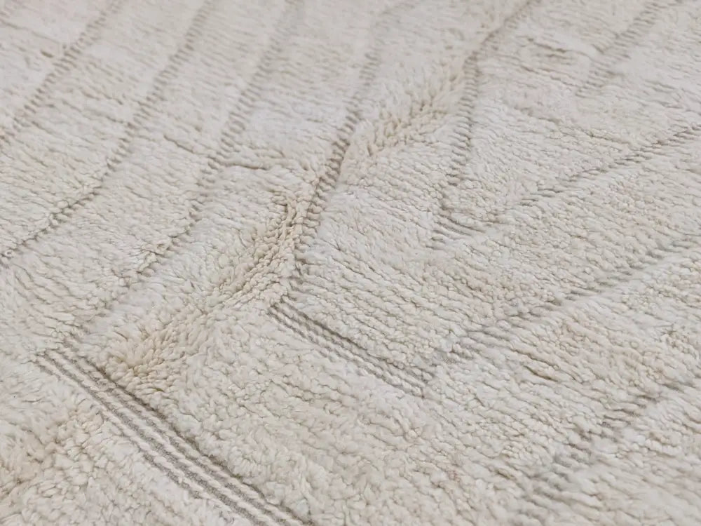Cream-colored plush bath towel with textured looped pile and gray geometric stripes featured with beni ouarain rug