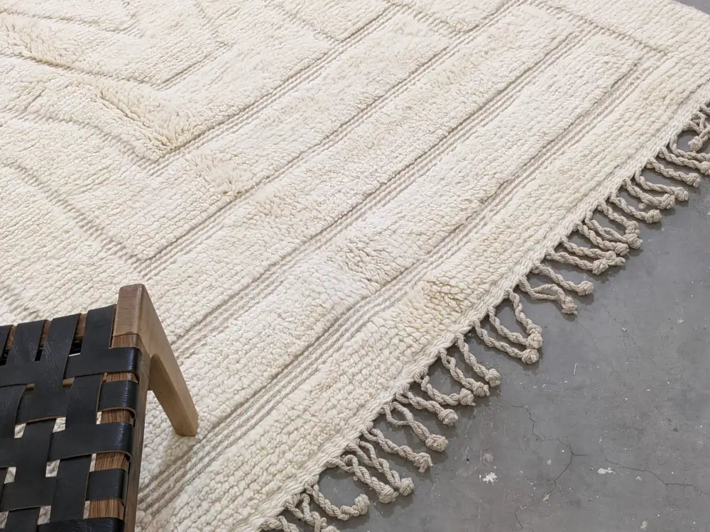 Cream-colored textured wool beni ouarain rug with geometric patterns and fringed edges moroccan handmade design