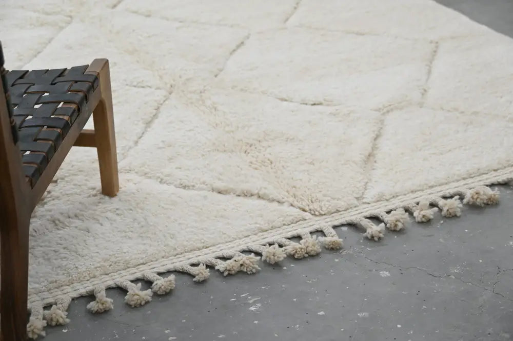 Cream-colored moroccan handmade beni ouarain rug with plush wool and geometric pattern with decorative tassels