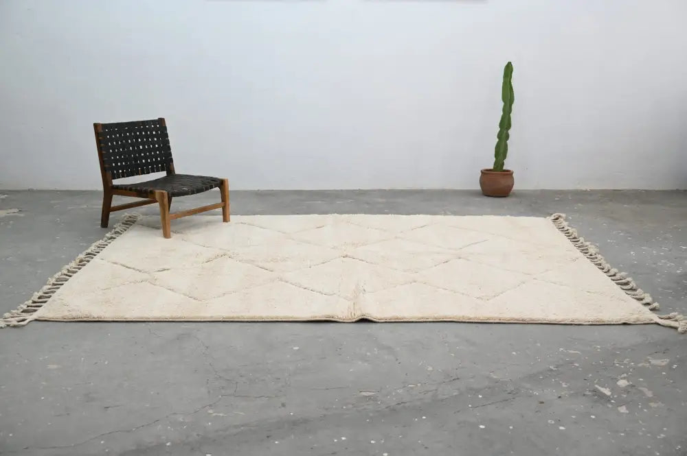 Cream-colored moroccan handmade beni ouarain rug with diamond pattern and fringed edges 300 x 212 cm by DecorBites