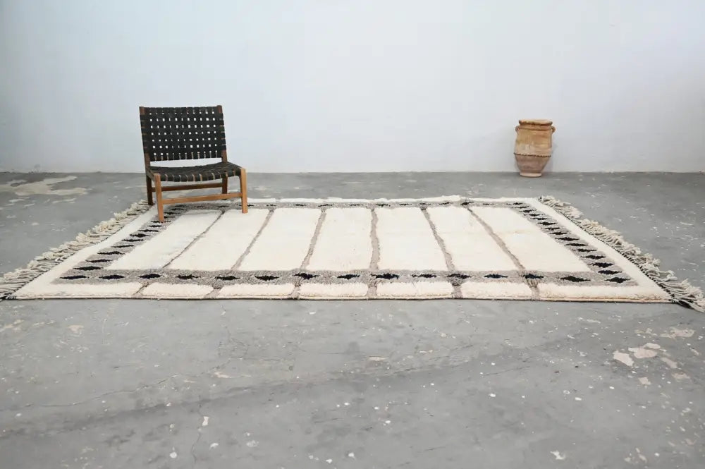 Cream-colored beni ouarain rug with black geometric patterns and fringed edges moroccan handmade wool decorbites