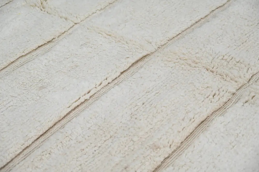 Cream-colored plush terry cloth beni ouarain rug with stitched seams dividing rectangular sections 303 x 205 cm