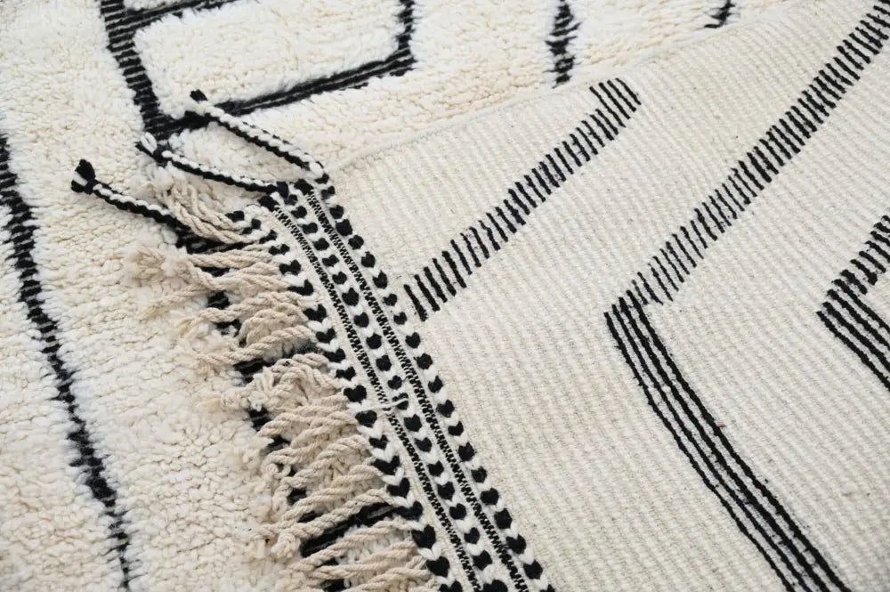Cream-colored beni ouarain rug with black geometric patterns and fringed edges moroccan handmade decorbites™ design