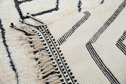 Cream-colored beni ouarain rug with black geometric patterns and fringed edges moroccan handmade decorbites™ design