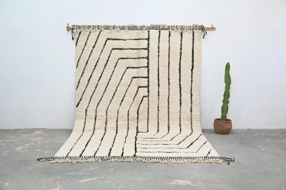 Cream-colored moroccan handmade beni ouarain rug with bold black geometric stripes and fringed edges 304 x 210 cm