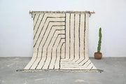 Cream-colored moroccan handmade beni ouarain rug with bold black geometric stripes and fringed edges 304 x 210 cm