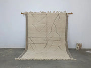 Beige moroccan handmade beni ouarain rug with geometric black line patterns and fringed edges 305 x 204 cm
