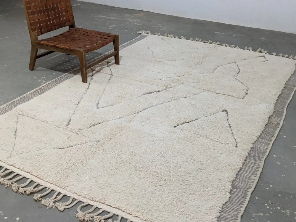 Cream-colored plush wool beni ouarain rug with geometric patterns and fringed edges moroccan handmade decorbites