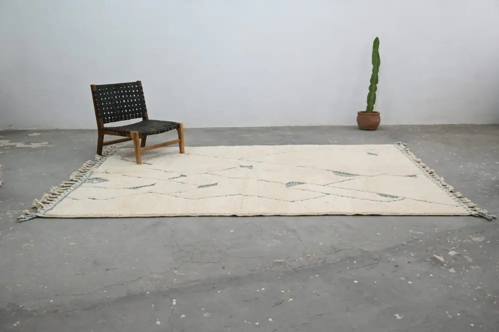 Cream-colored beni ouarain rug with dark gray geometric patterns and fringed edges moroccan handmade traditional style