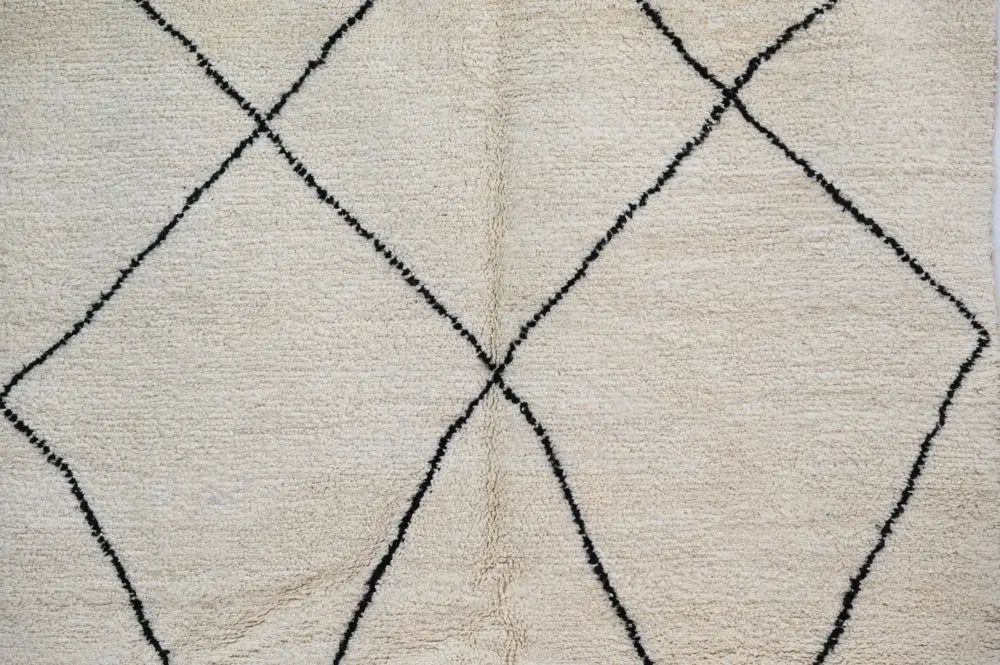Cream-colored beni ouarain rug with bold black geometric diamond patterns moroccan handmade wool decorbites
