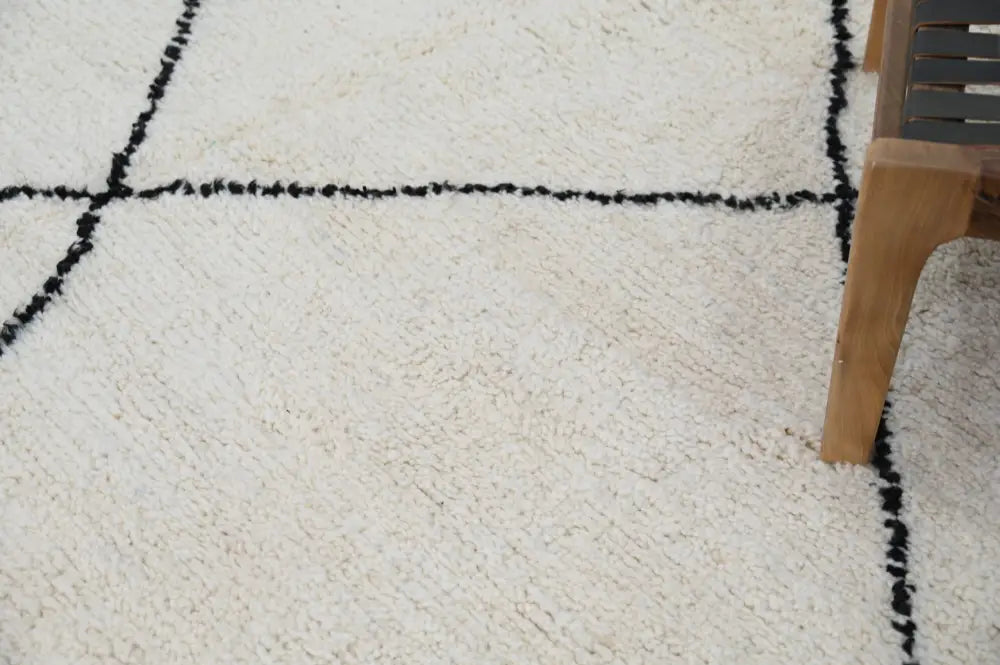 Cream-colored moroccan handmade beni ouarain rug with plush wool and bold black geometric border lines 309 x 204 cm