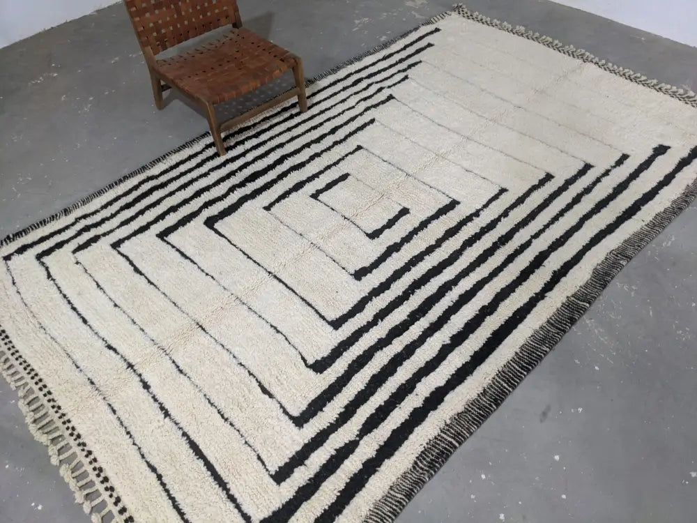 Cream-colored beni ouarain rug with bold black geometric stripes and fringed edges moroccan handmade wool design
