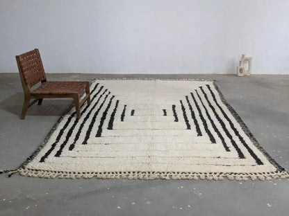 Cream-colored beni ouarain rug with bold black geometric stripes and fringed edges moroccan handmade traditional design
