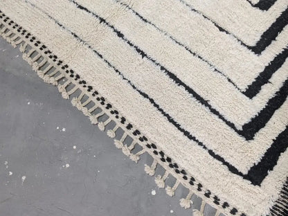 Cream-colored plush wool beni ouarain rug with bold black geometric stripes and decorative tassels moroccan handmade