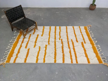 A moroccan handmade beni ouarain rug with cream and mustard yellow stripes and fringed edges by decorbites