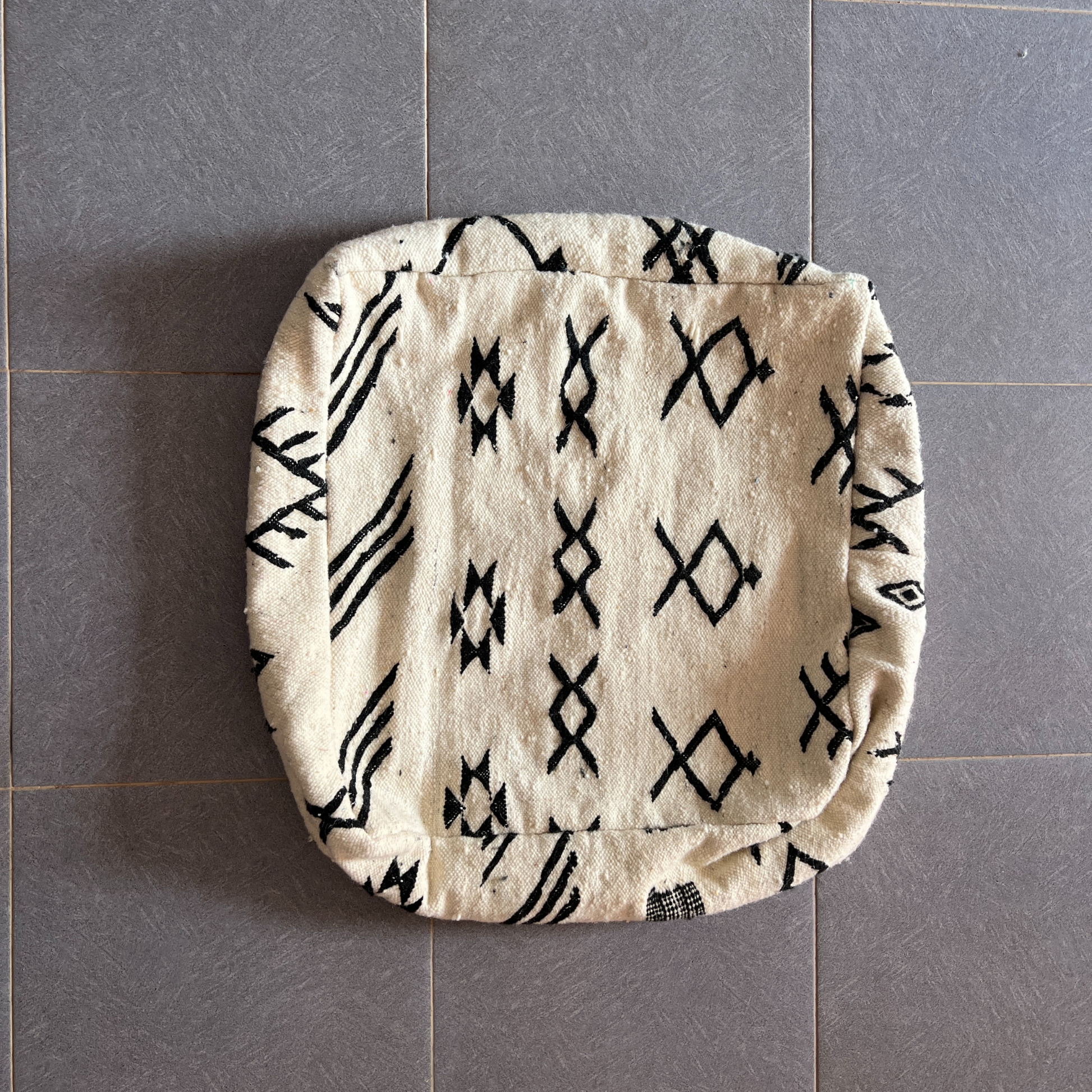Cream-colored decorbites moroccan handmade pouf 60cm x 60cm with black geometric woven textile design
