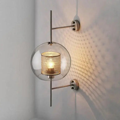 Modern bathroom wall sconce with gold-toned perforated metal shade and clear glass globe from decorbites™ moroccan modern collection