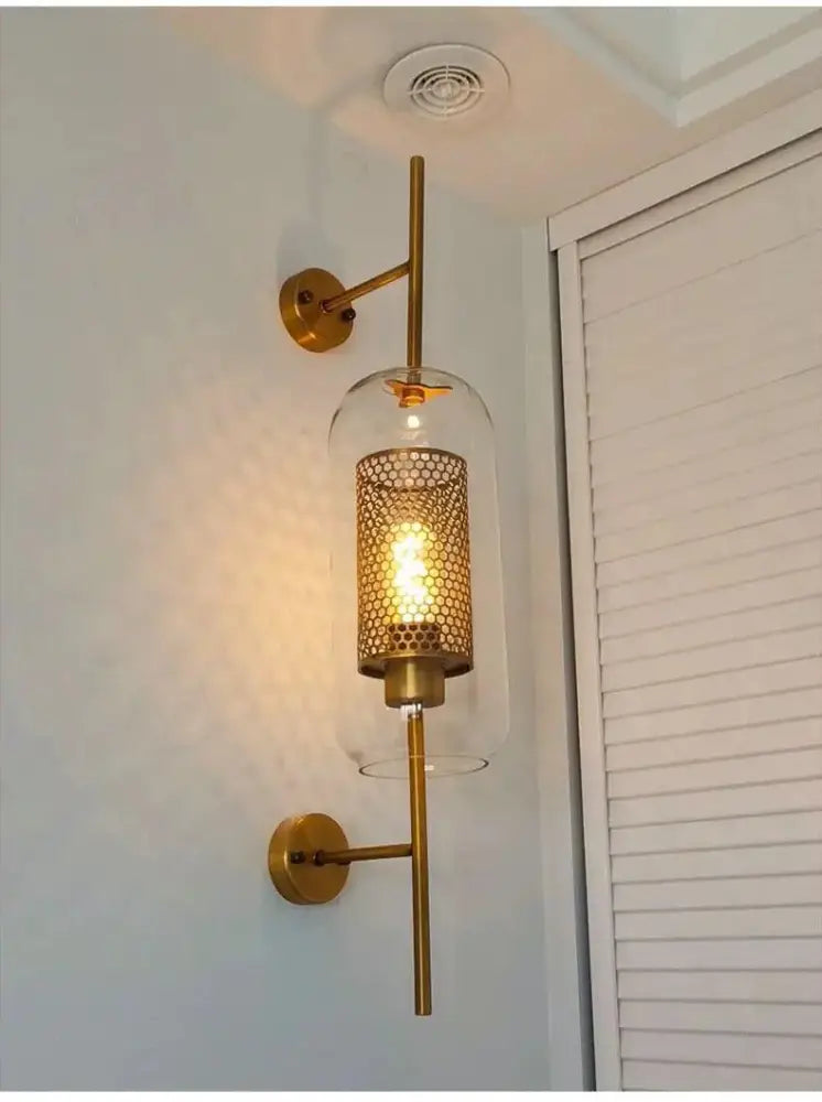 Gold-toned DecorBites™ Moroccan modern bathroom wall sconce with clear glass dome and honeycomb metal shade
