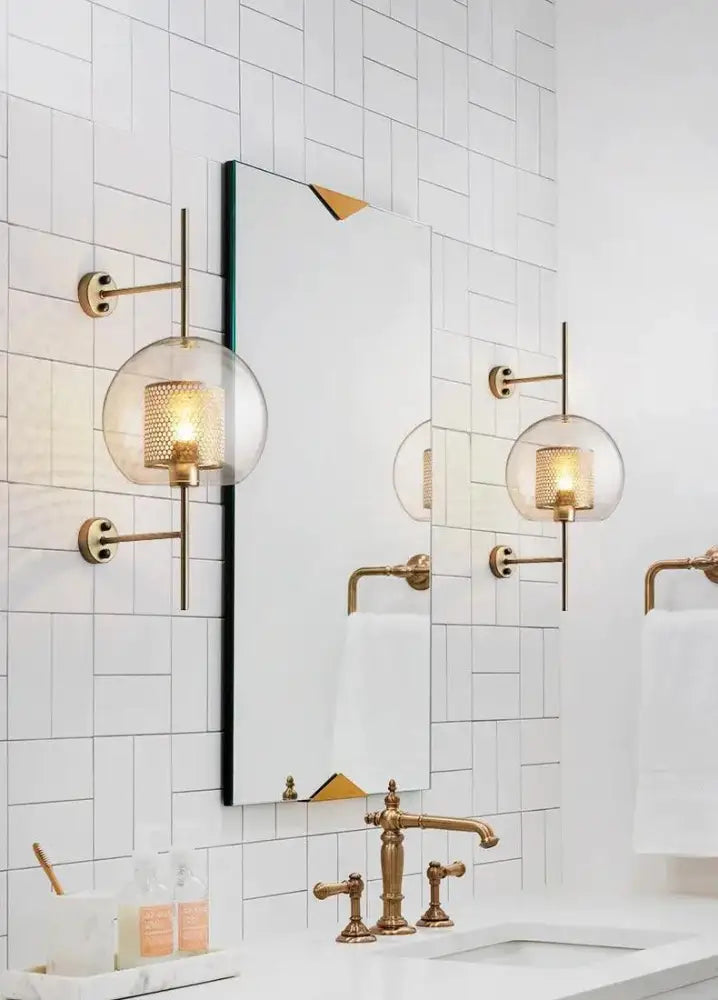 Gold-toned decorbites™ moroccan modern bathroom wall sconce with spherical glass shades and mesh interiors for modern bathroom wall use