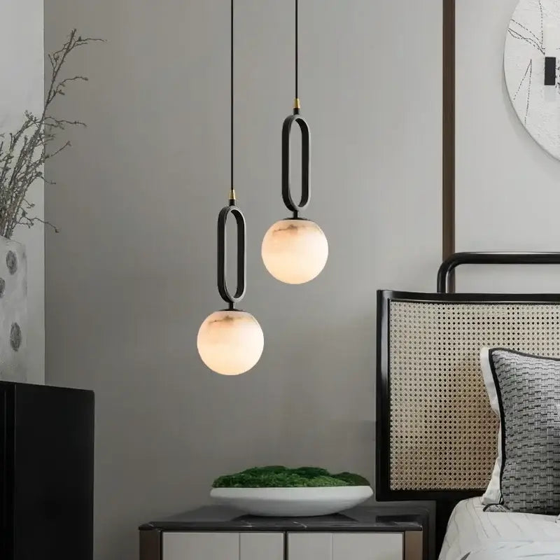 Two decorbites™ moroccan white marble pendant lights with black metal frames and frosted glass globe shades with led bulbs