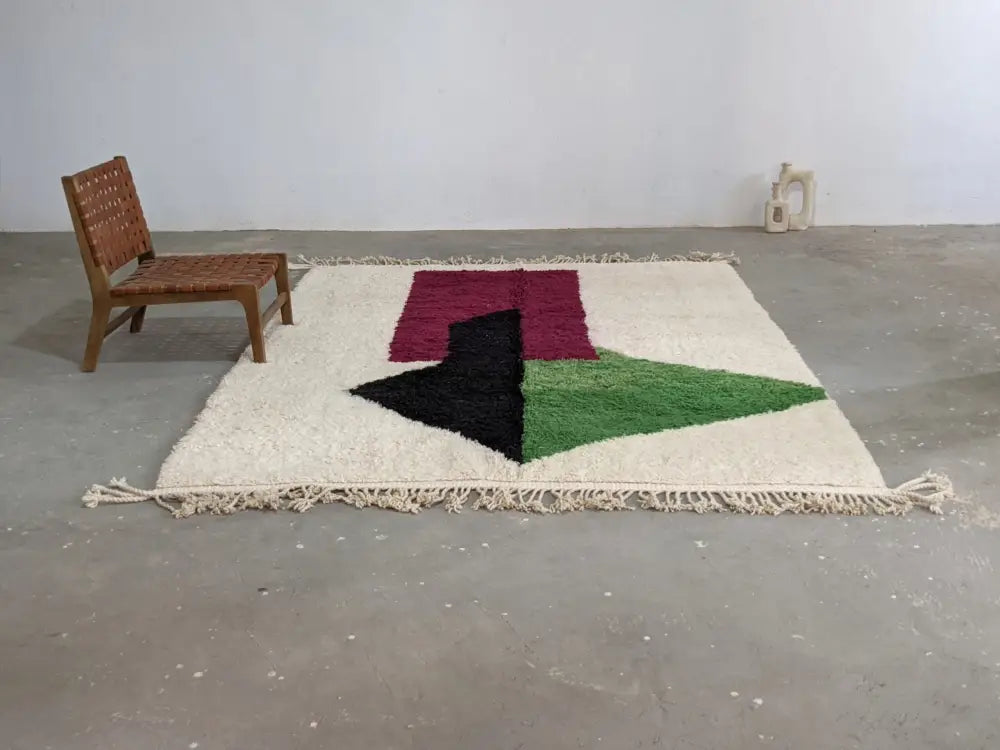 Cream-colored wool traditional azilal rug with bold maroon black and green geometric triangular design 298x220cm by DecorBites