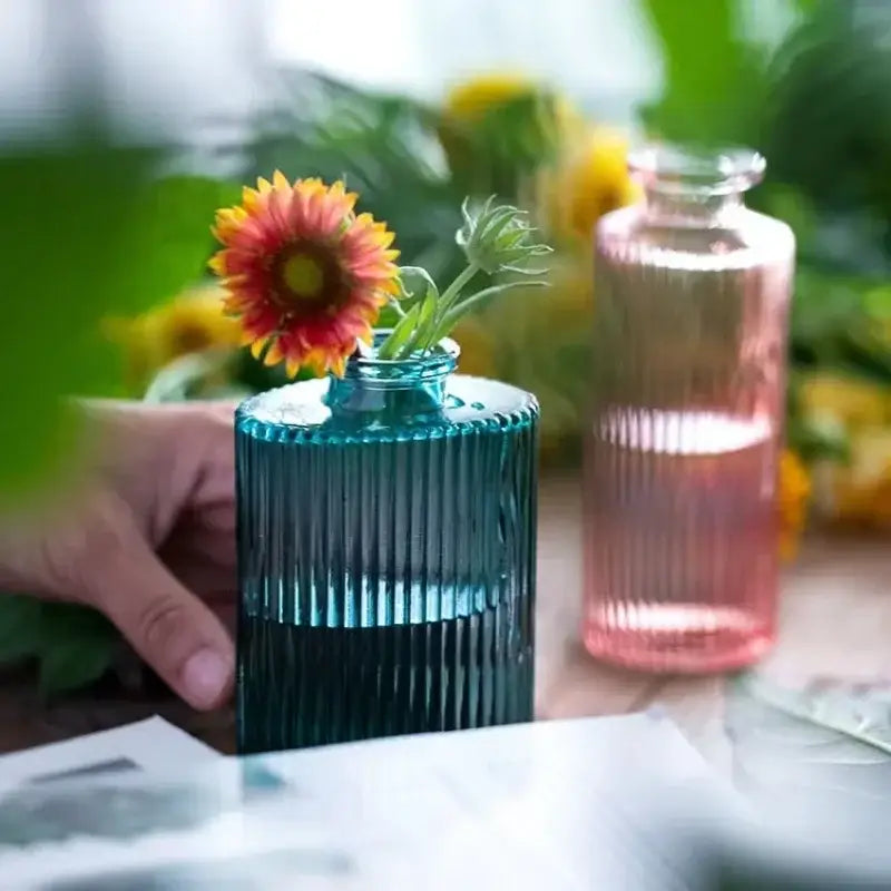 DecorBites teal ribbed glass vase with 2cm opening holding an orange and yellow flower as a decorative flower pot